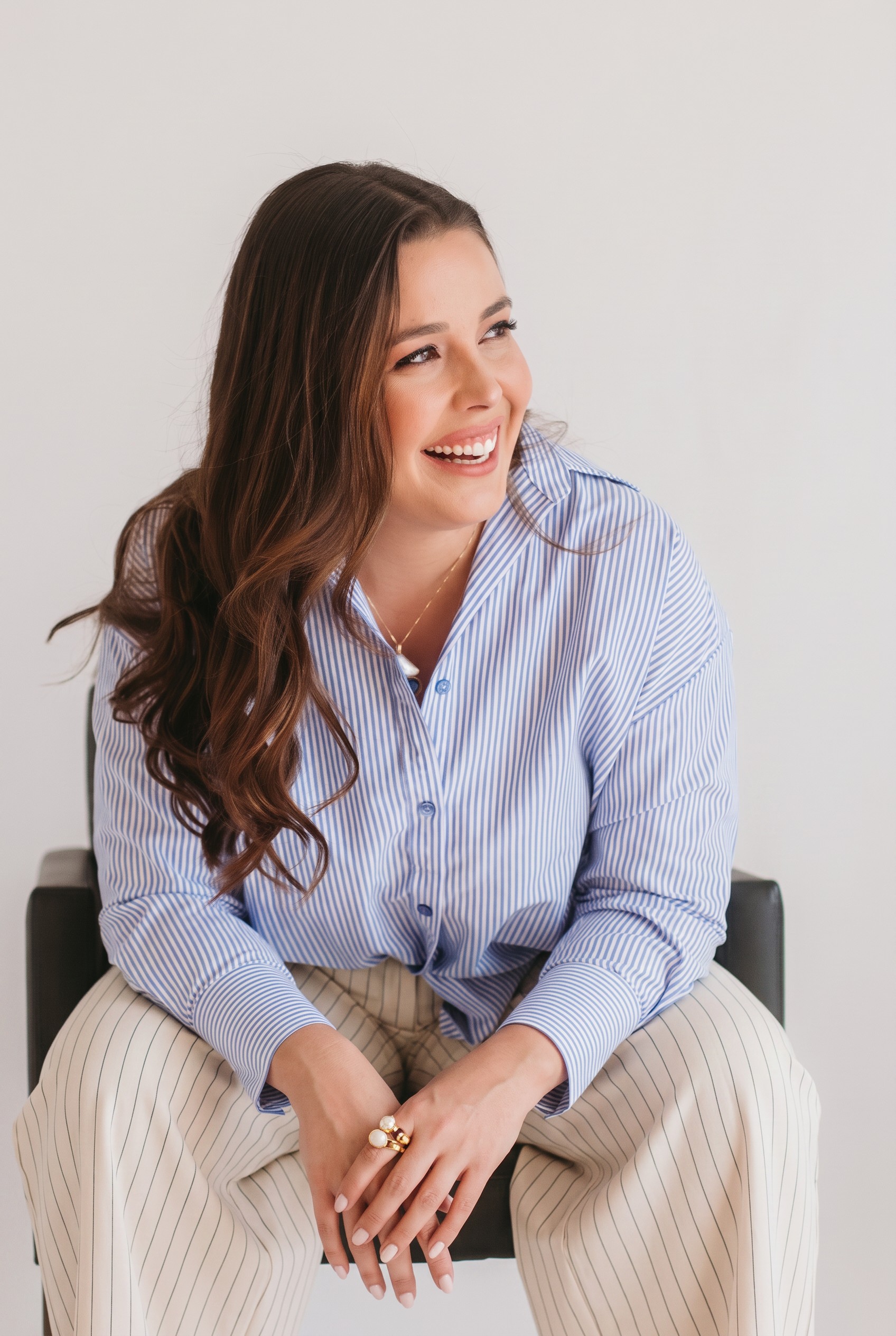 Raquel Perroni sorrindo com camisa clara